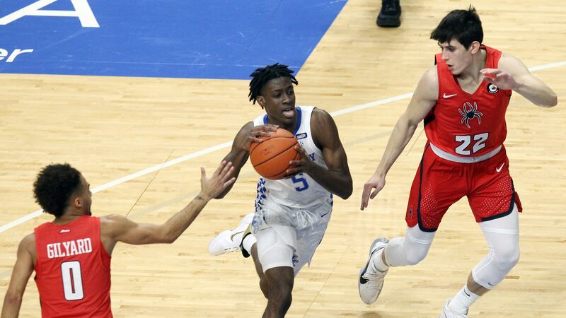 Kentucky's Terrence Clarke, center, drives between Richmond's Jacob Gilyard (0) and Andre...