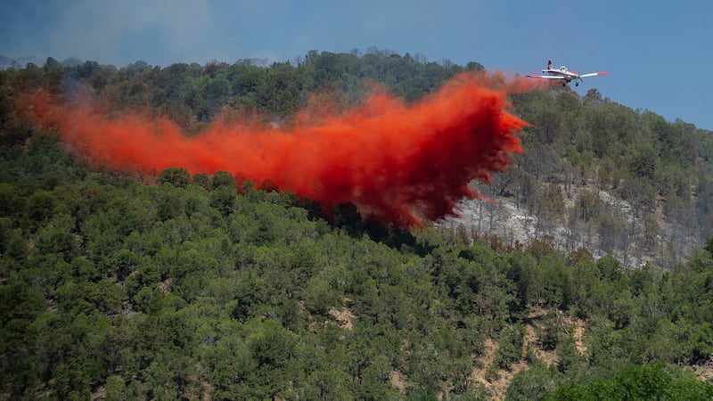 FILE - A plane drops fire retardant near the Lake Christine wildfire on July 4, 2018, in...