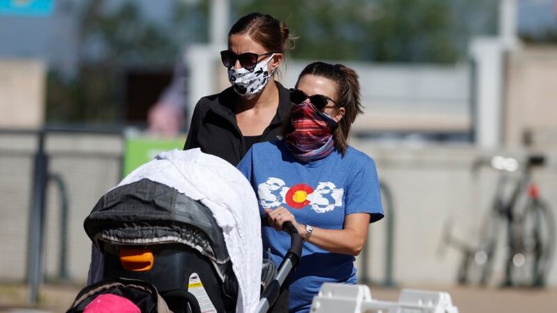 Visitors wear face coverings as they head to the entrance to the Denver Zoo as it reopens...