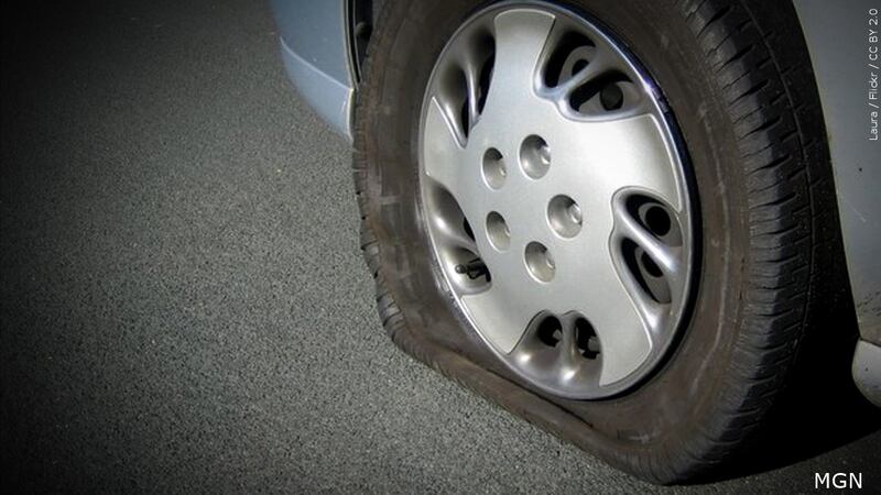 FILE - The vehicle had a flat tire along Route 8, and the driver tried to change the tire.